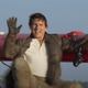 Tom Cruise waving hello in the sky on a little red plane